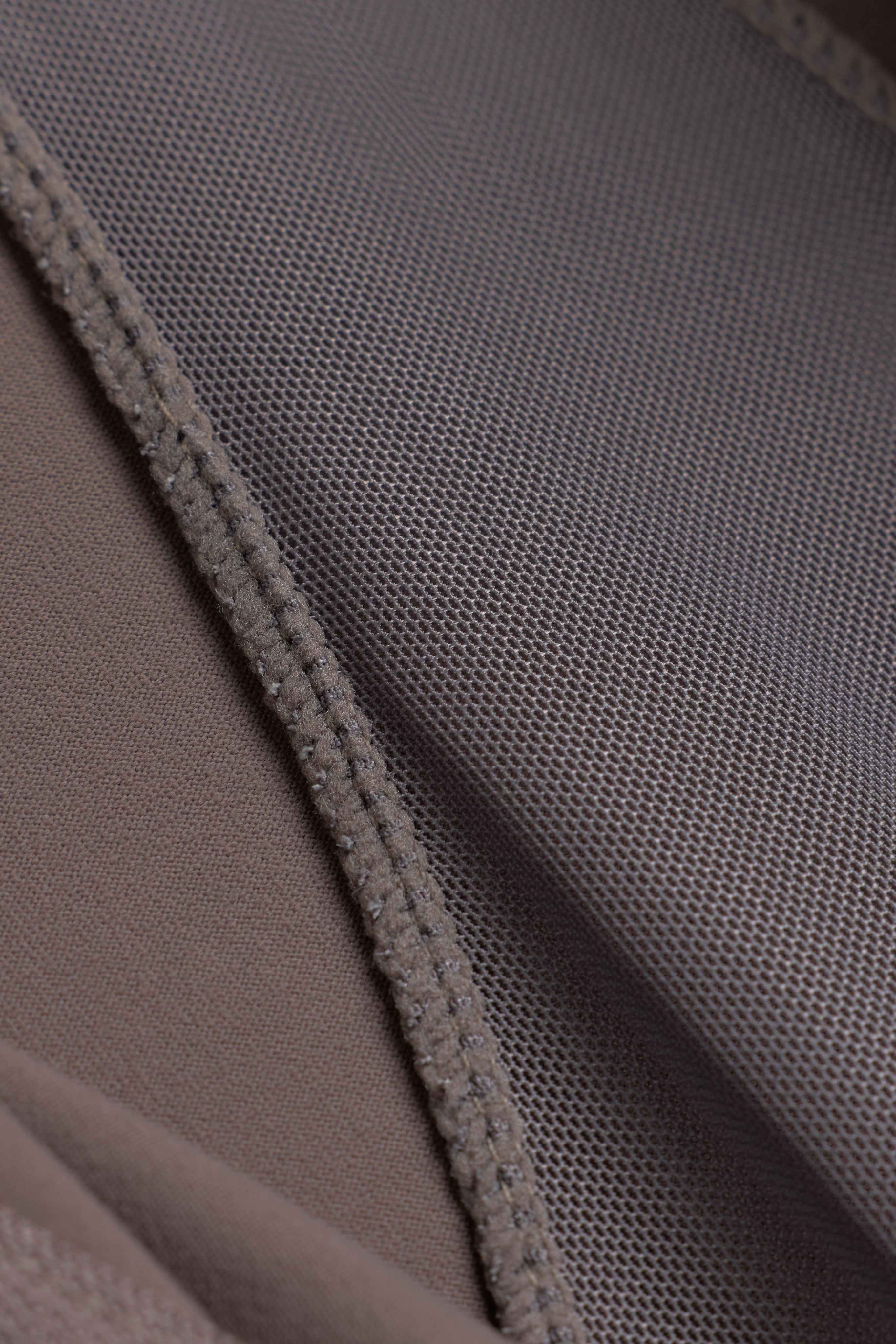 Close-up of the breathable mesh fabric and seam on the walnut CASPARA Sculptluxe Zip Jacket.